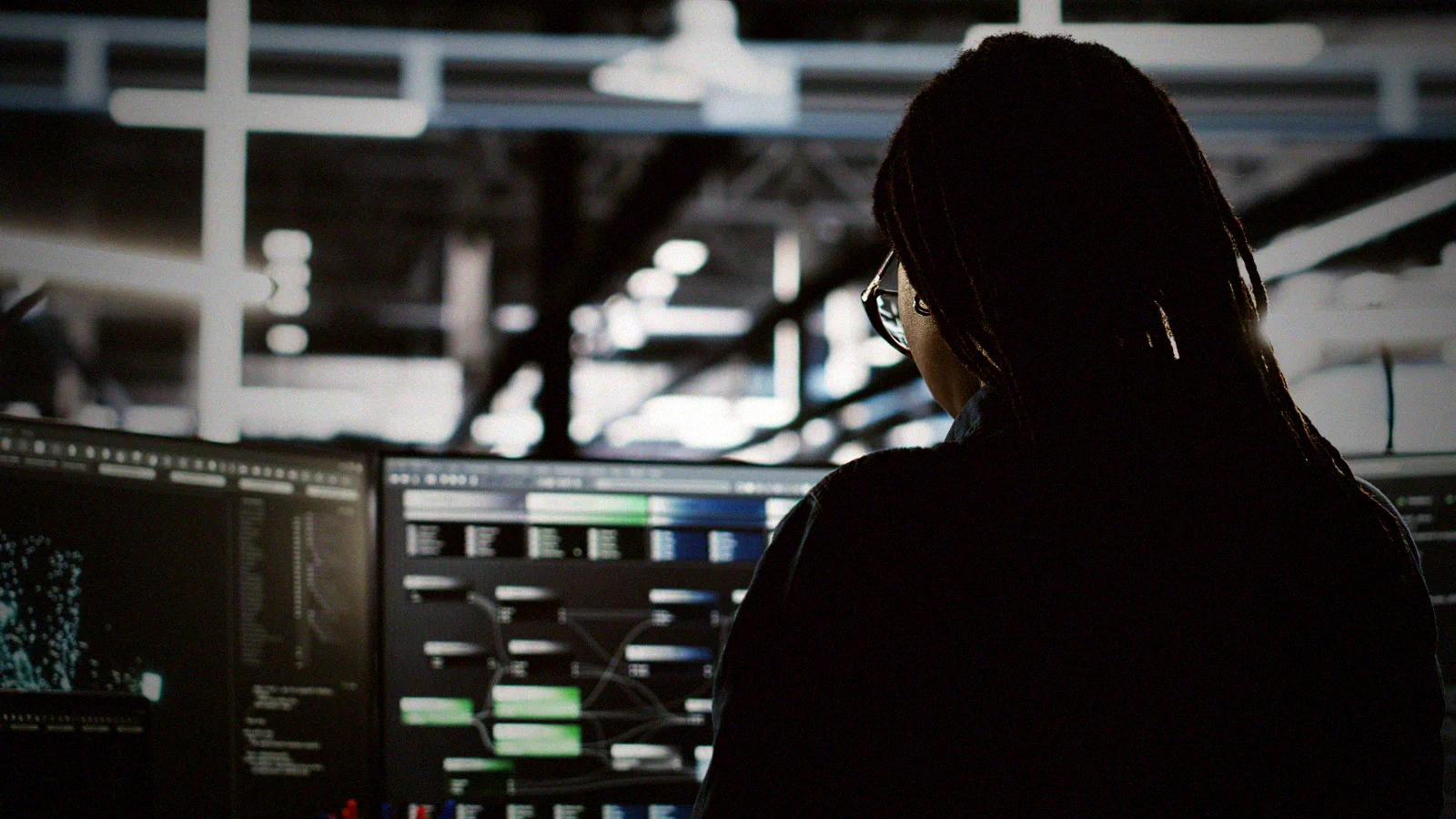 A systems administrator traces node telemetry across a live monitoring console in a data centre.